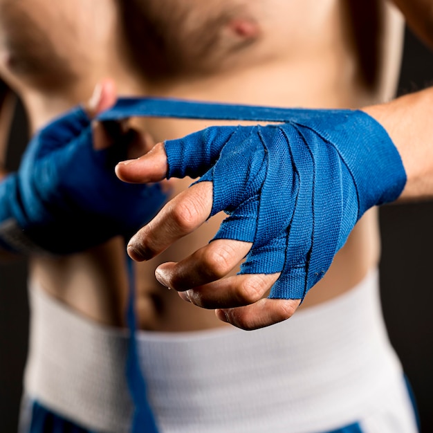 Free photo front view of man putting on protection for hands