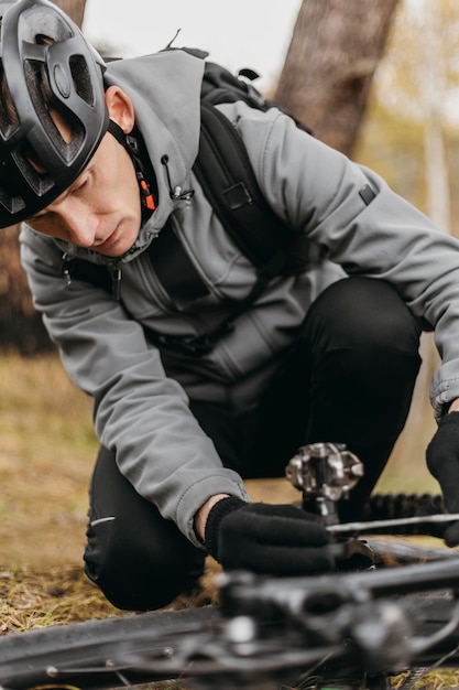 Free Photo front view of man riding a bike in mountain