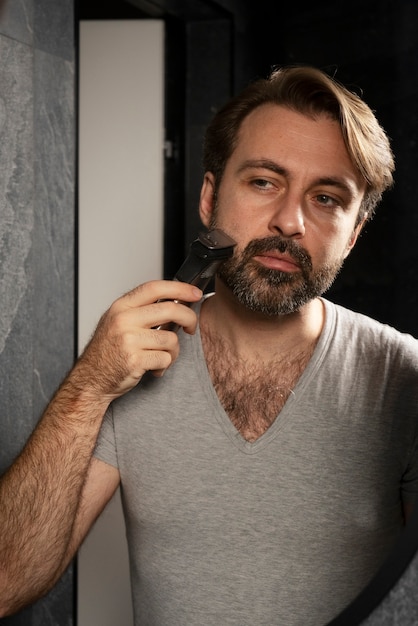 Front view man shaving at home