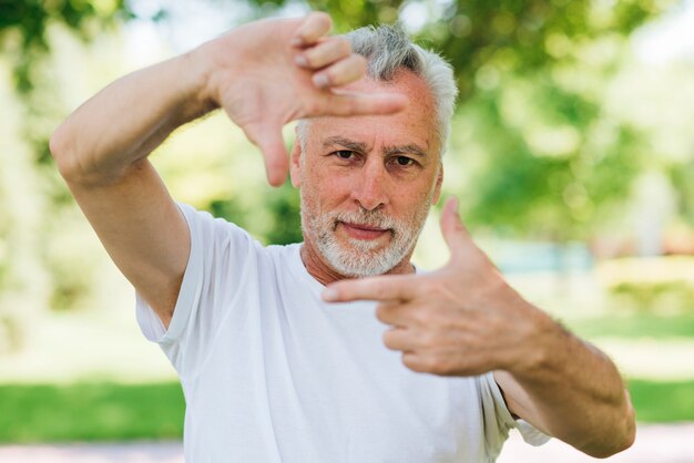 Front view man showing camera hands gesture