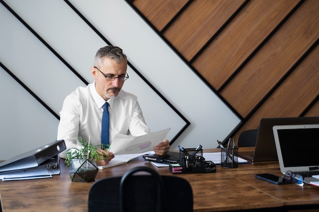 Front view man sitting at desk