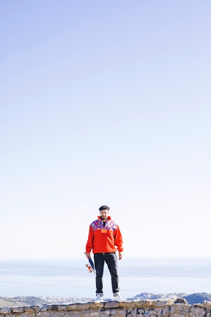 Front view of man standing on stone wall