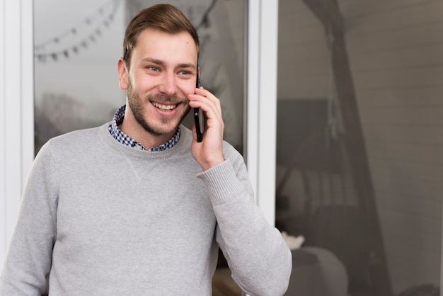 Front view of man in sweater talking on the phone