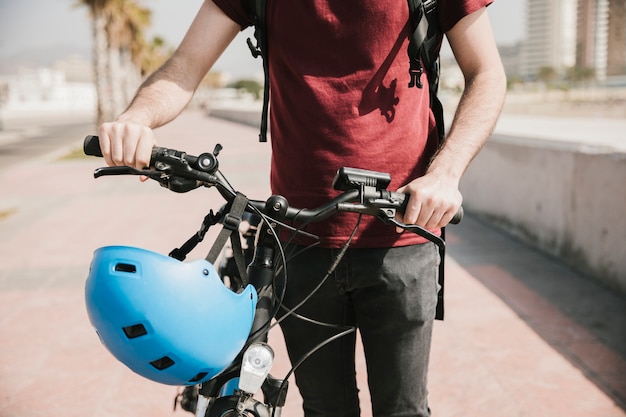 Free photo front view man walking next to bicycle