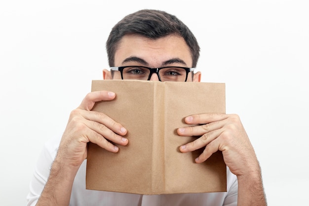 Free Photo front view of man wearing glasses and holding book close to face