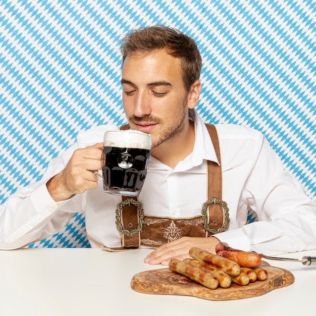 Free photo front view of man with beer and sausages