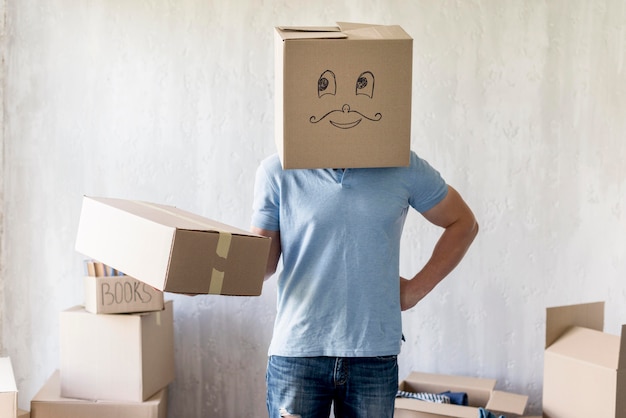 Free Photo front view of man with box over head posing while packing to move