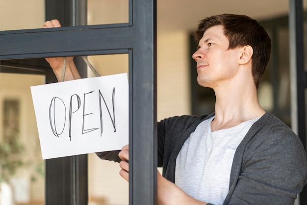 Free photo front view of man with open sign