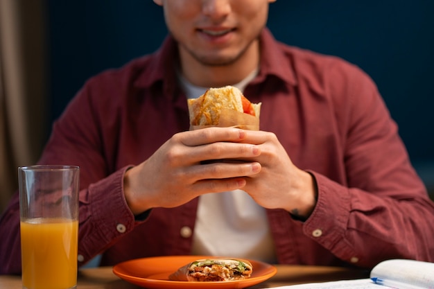 Free photo front view man with  paper-wrapped sandwich