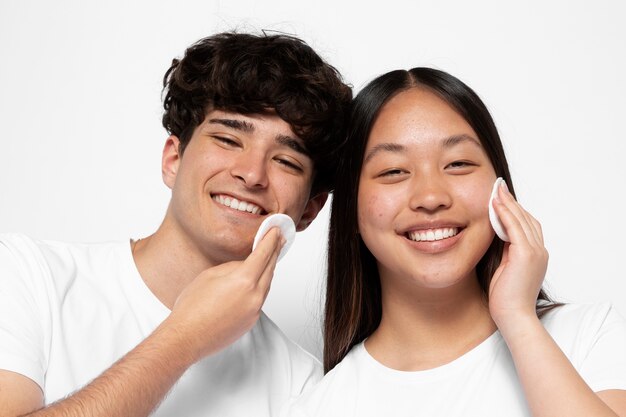 Front view man and woman using cotton pads