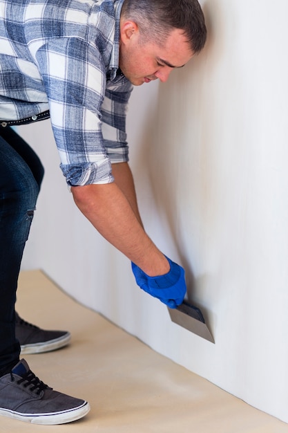 Free Photo front view of a man working on a wall