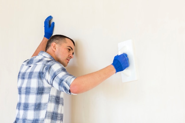 Free Photo front view of man working on wall