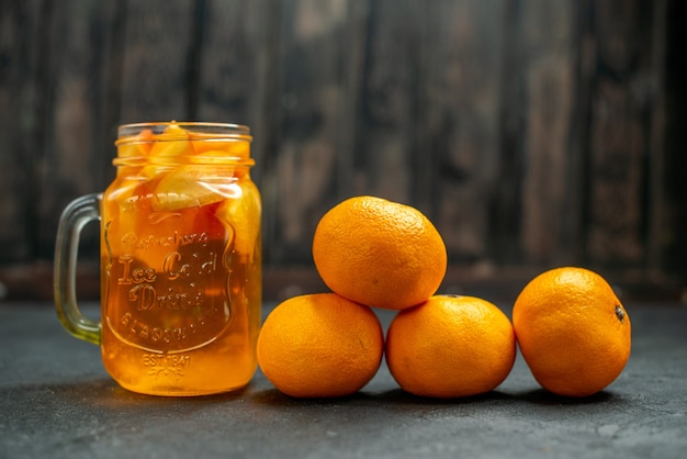 Free photo front view mandarines cocktail on dark background free space