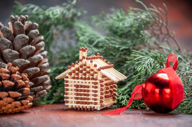 Front view matchstick house xmas tree ball toy pine tree branch with pinecone new year photo