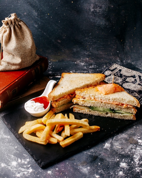 Front view meal black desk with french fries and sandwich on the grey floor