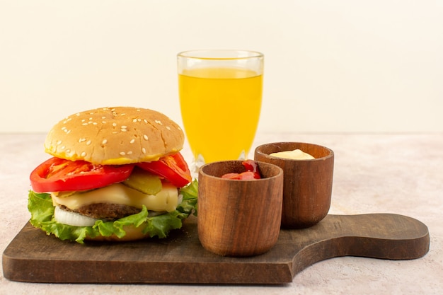 A front view meat burger with cheese and green salad along with ketchup and mustard on the wooden table