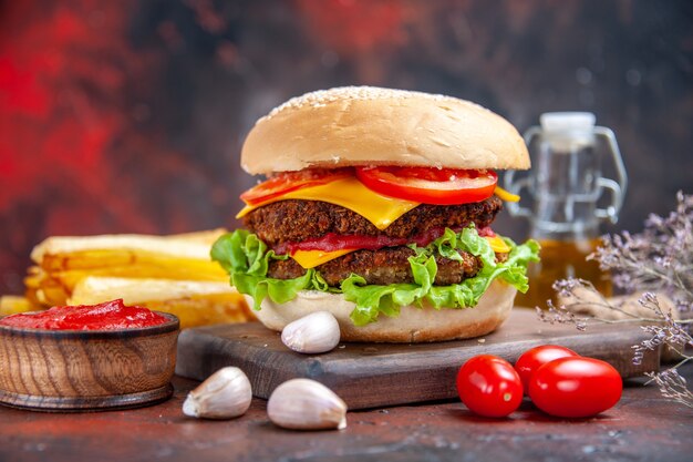 Front view meat burger with cheese salad and tomatoes on dark background