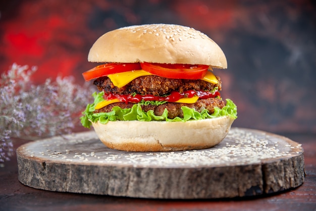 Front view meat burger with cheese salad and tomatoes on dark background