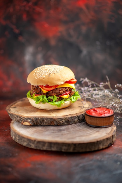 Front view meat burger with salad cheese and tomatoes on dark desk bun sandwich fast-food