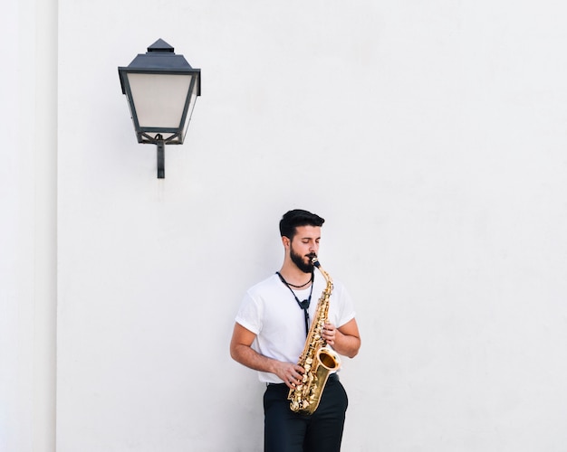 Free photo front view medium shot musician playing the saxophone