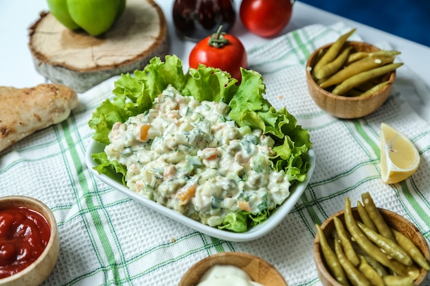 Front view metropolitan salad with ketchup and mayonnaise tomatoes and peppers on the table