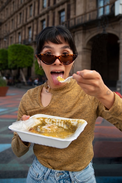 Free photo front view mexican woman eating ranchero food