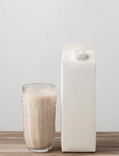 Free photo front view of milk carton with full glass