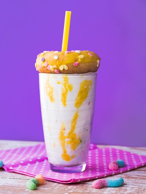 Free photo front view of milkshake glass with purple background