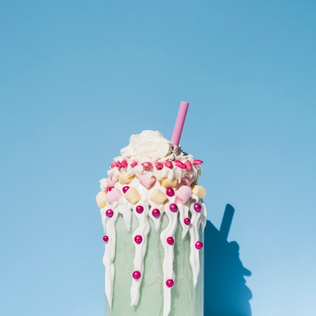 Front view of milkshake with blue background