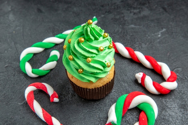 Free Photo front view mini xmas tree cupcake and xmas candies on dark background