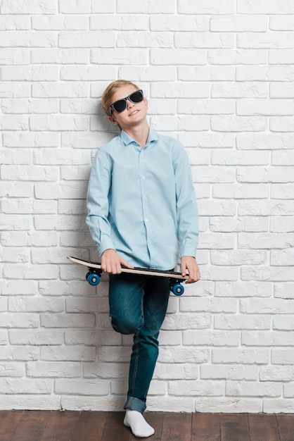 Free Photo front view of modern boy with skateboard