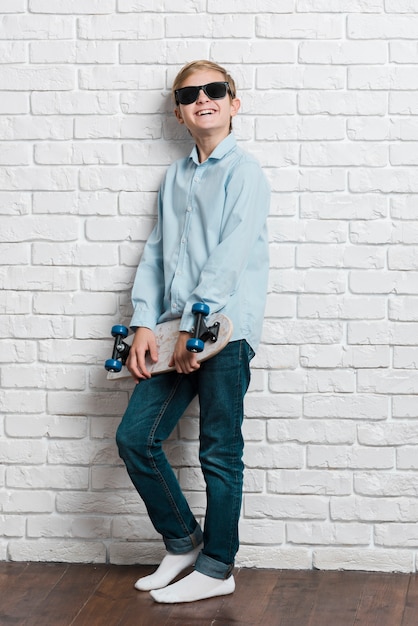 Front view of modern boy with skateboard