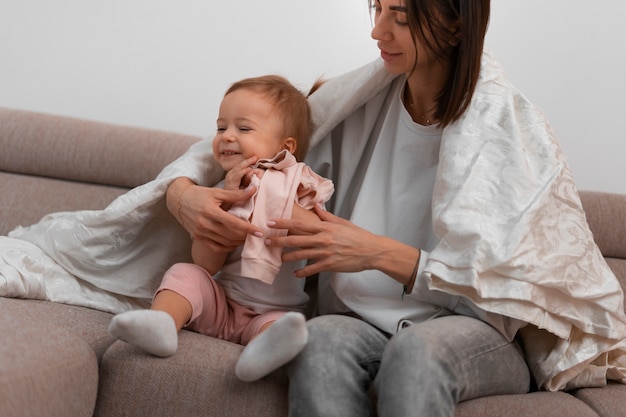 Front view mother dressing baby