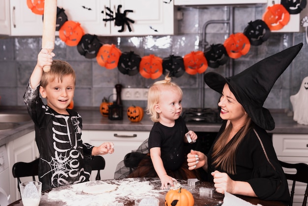 Free photo front view of a mother and her childrens making halloween cookies