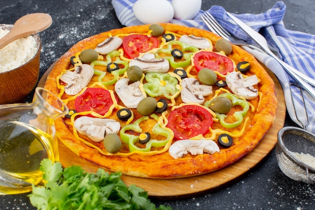 Front view mushroom pizza with red tomatoes bell peppers olives and mushrooms all sliced inside with eggs on dark