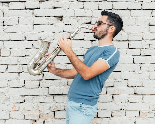 Free photo front view of musician playing saxophone concept