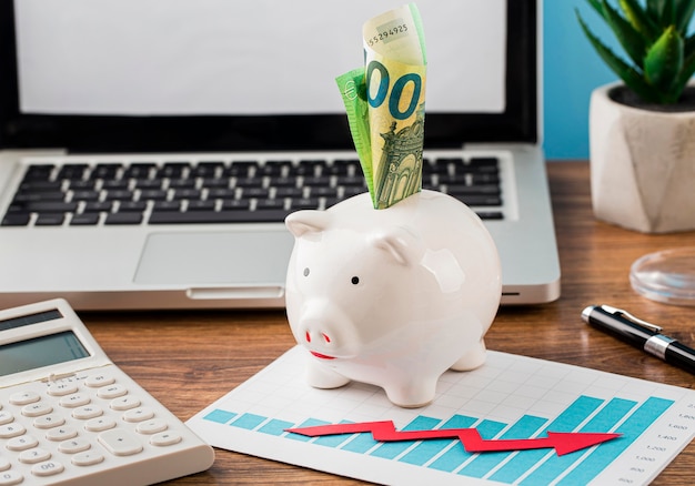 Front view of office items with piggy bank and growth chart