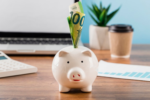 Free photo front view of office items with piggy bank