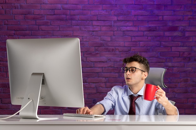 Free photo front view office worker behind office desk working