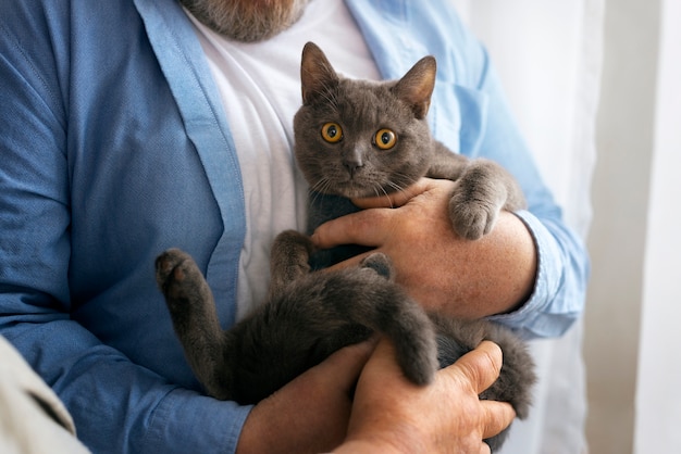 Free photo front view old man holding cat