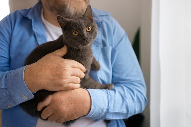 Free Photo front view old man holding cat