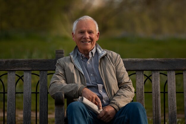 Free photo front view old man sitting on bench