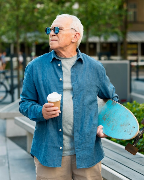 Free photo front view of old man with skateboard