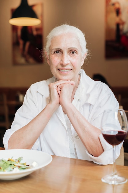 Front view old woman posing at restaurant