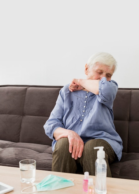 Free Photo front view of older woman coughing while at home