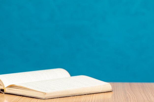 Front view open book on wooden table