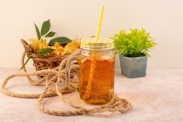 A front view orange peeled physalises inside basket with juice on the pink desk  