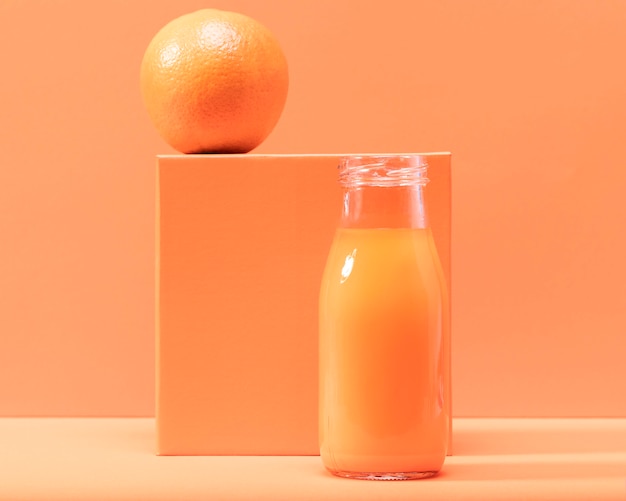 Free photo front view orange and smoothie in bottle