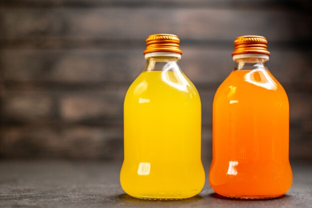 Front view orange and yellow juice in bottles