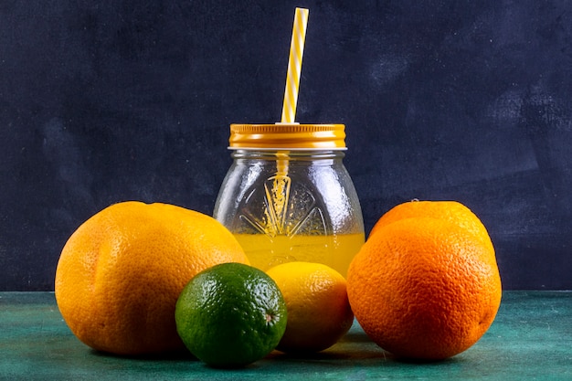 Front view oranges with lime  lemon and orange juice in a jar